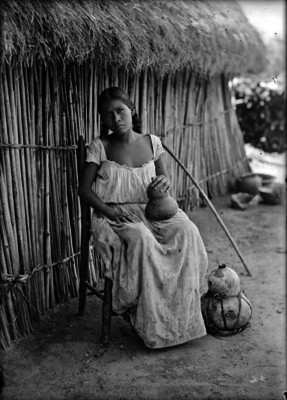 Mujer sentada afuera de una choza en Xochicalco, retrato