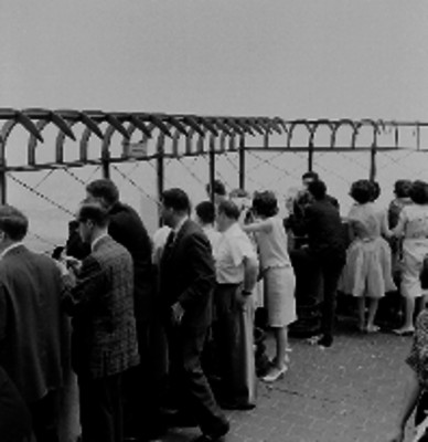 Visitantes de la Empire State observando la ciudad en lo alto de un edificio
