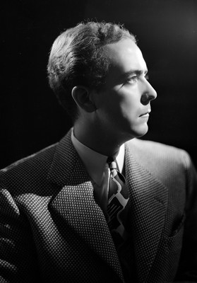 Guillermo Calderon con rostro de perfil derecho y traje formal, retrato
