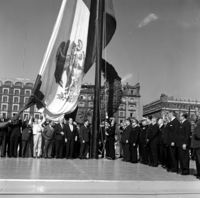Adolfo López Mateos con miembros de su comitiva izando la bandera monumental en el zócalo de la cd. de México