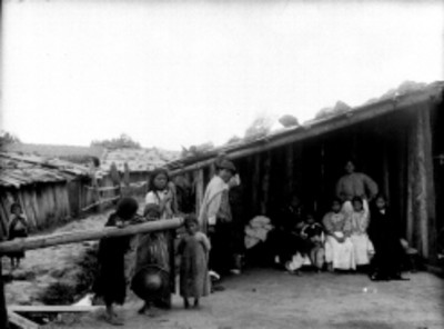 Familia indígena en el patio de una vivienda, retrato de grupo