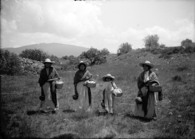 Mujeres y niña otomíes con canastas en un paraje, retrato de grupo