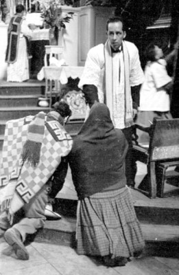 Feligreses besan la mano a sacerdote durante una misa