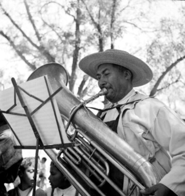 Músico toca la tuba en un jardín