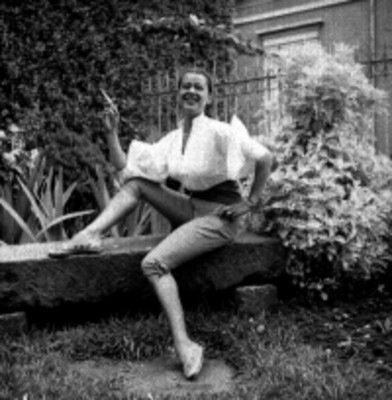 Mujer modela pantalón en un jardín, retrato