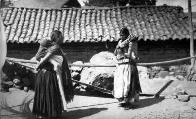 Mujeres purépechas cargando a niños en la espalda