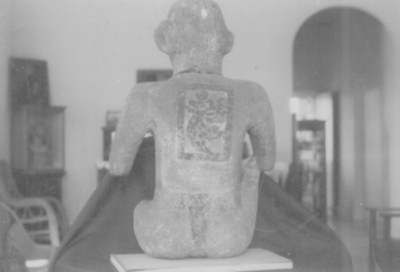 Escultura prehispánica de un personaje sedente con inscripción calendárica en la espalda