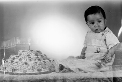 Niño de clase media ante pastel de cumpleaños, retrato