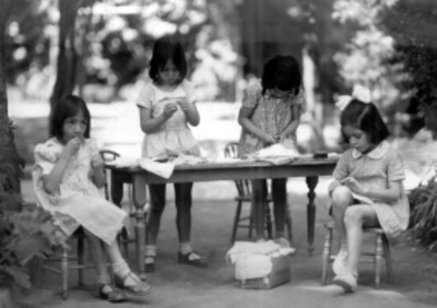 4 niños de aproximadamente 5 años trab ajado con papel al aire libre, retrato