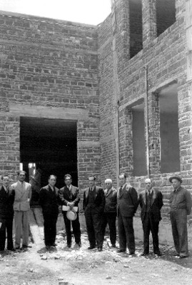 Grupo de funcionarios a las afueras de una construcción, retrato