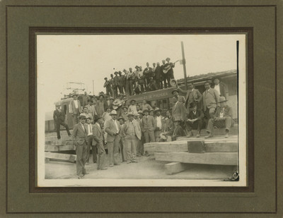 Grupo de hombres junto a vagón de ferrocarril