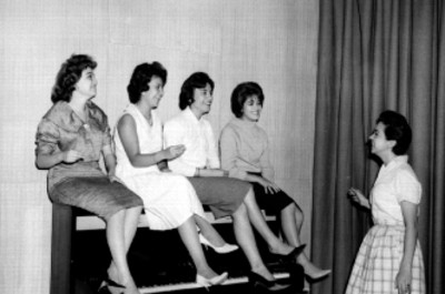 Mujeres cantando sobre un piano durante el ensayo de una obra teatral