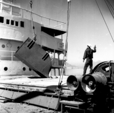 Trabajador dirigiendo una tolva que vierte trigo en una bodega del barco Constitución