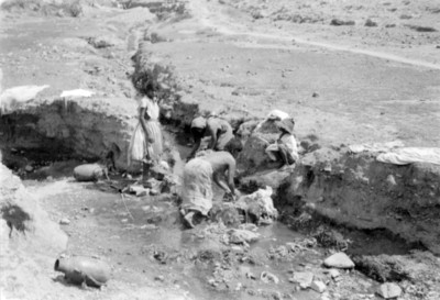 Mujeres con niños lavan ropa en un arroyo del Valle del Mezquital