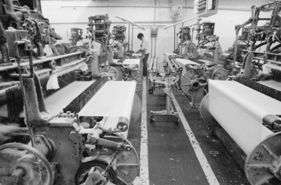Obrero trabaja con maquinaria textil en la fábrica de Miraflores