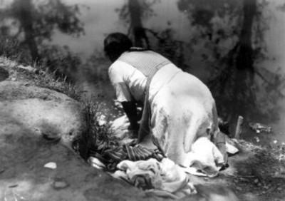 Mujer Otomie lavando cerca de un río