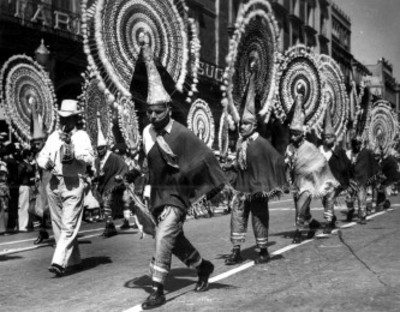 Hombres realizan la danza de la Pluma durante un desfile