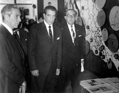 El licenciado Adolfo López Mateos y comitiva recorren una sala de exhibición organizada por el I.N.I.