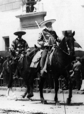 Gral. Francisco Ramírez y otros rurales a caballo, desfilan por una calle