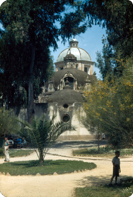 Niños en un jardin junto a una iglesia