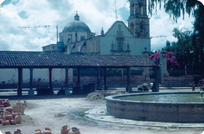Iglesia con plaza publica en primer plano, vista parcial