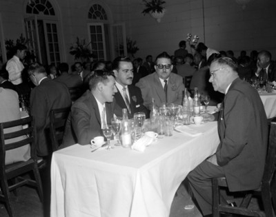 Hombres conversan durante reunión social en un salón
