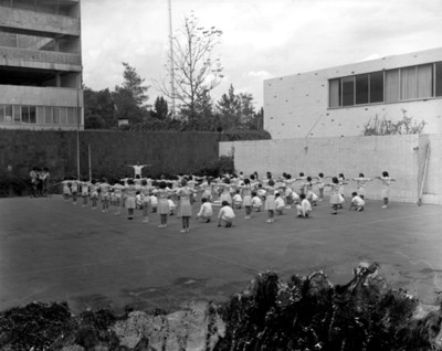 Niños durante clase de educación fisica en el patio de una escuela