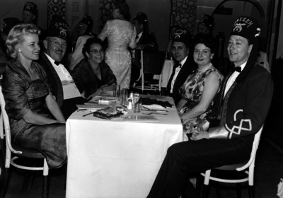 Músicos de la banda Shainers y mujeres en la mesa, durante un evento social