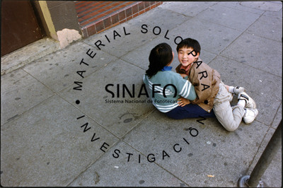 Niños juegan en la calle sobre una banqueta