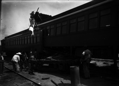 Ferrocarrileros levantando fierros de un choque entre dos vagones de pasajeros