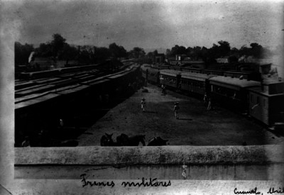 Trenes militares en patios de una estación ferroviaria, vista panorámica
