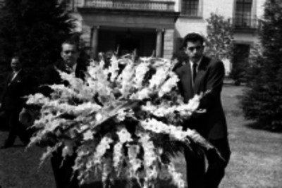 Hombres trasladando una ofrenda floral para la tumba de Manuel Ávila Camacho padre