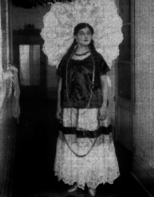 Mujer tehuana con traje tipico en el pasillo de un edificio, retrato