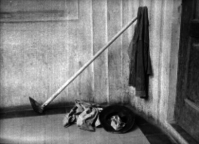 Ropa y sombrero de un hombre en el quicio de una puerta