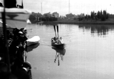 Hombres saludando abordo de una lancha, en el Lago de Chapultepec