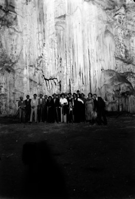 Refugio Zapata de Casasola y excursionistas junto a estalactitas en las Grutas de Cacahuamilpa, retrato de grupo