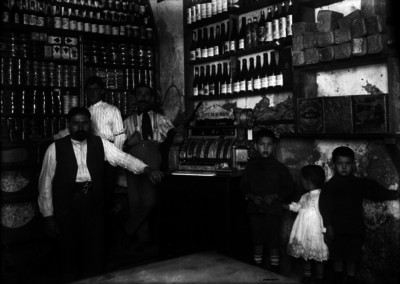 Hombres y niños posan en interior de tienda de abarrotes