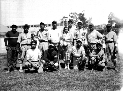 Equipo de beisbol y mujer con trofeo, retrato de grupo