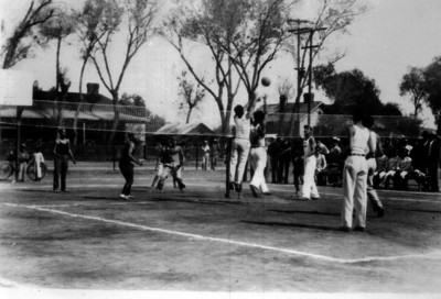 Deportistas saltan para pegarle al balón durante un partido de voleibol
