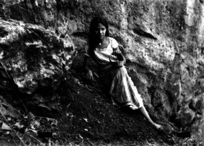 Adolescente indígena con canasta sentada al pie de cerro, retrato
