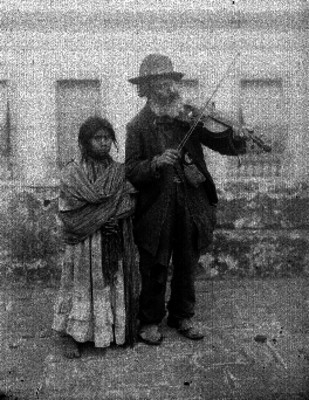 Hombre de aspecto humilde tocando un violín en una calle