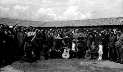 Hombres acompañados de un mariachi, retrato de grupo
