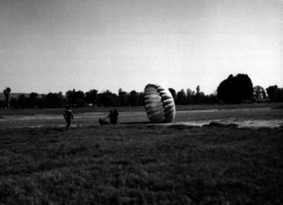 Hombres ayudando a un paracaidista al aterrizar