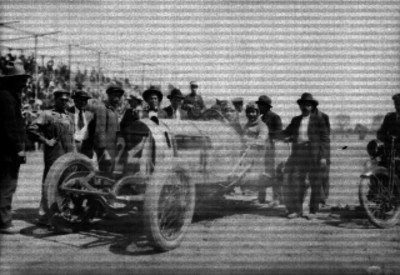 Piloto en su auto de carreras acompañado por varios hombres en el autódromo de Chapultepec, retrato de grupo