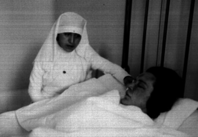 Enfermera cuidando a una mujer herida en un hospital