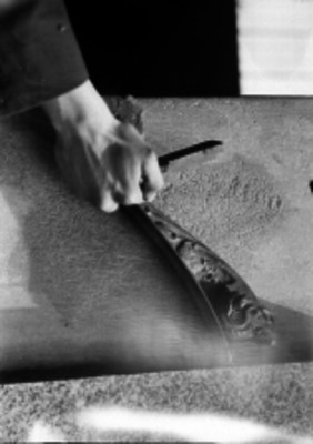 Mano sujetando un herraje en una pared