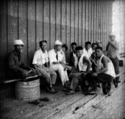 Pescadores japoneses sentados en el puerto, retrato de grupo