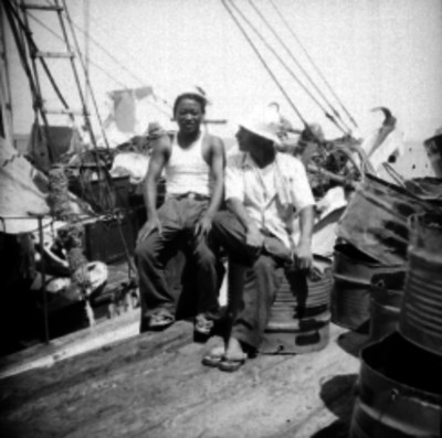 Pescadores sentados en unos tambos en el muelle, retrato