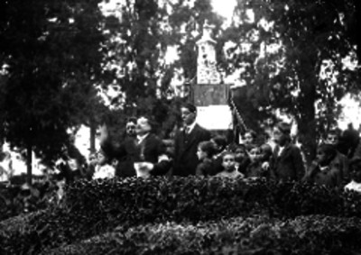 Individuos de una agrupación patriótica en un evento cívico en un parque