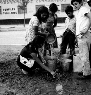 Mujer llena una cubeta con agua